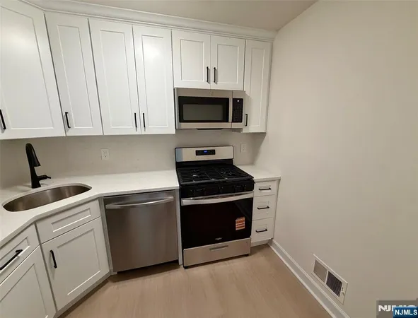 a kitchen with stainless steel appliances granite countertop a stove a microwave and a sink