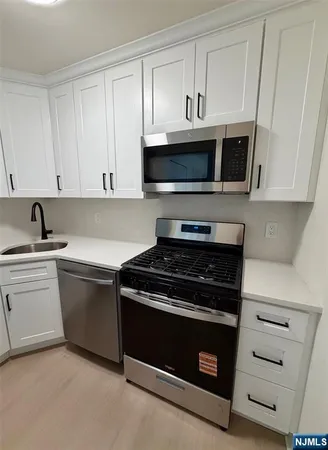 a kitchen with cabinets stainless steel appliances and a sink