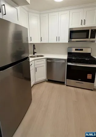 a kitchen with a refrigerator stove and white cabinets