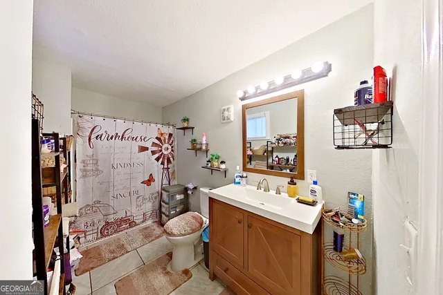 a bathroom with a sink mirror vanity and toilet