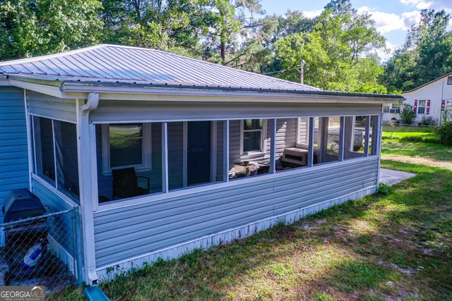 a view of a house with a yard and furniture