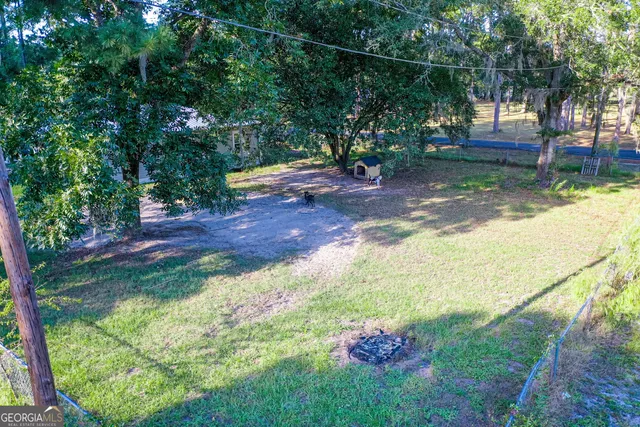 a backyard of a house with lots of green space and fountain