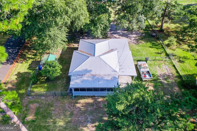 an aerial view of a house with a yard and a large tree