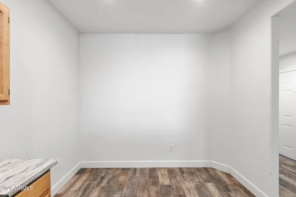 an empty room with wooden floor and chandelier fan