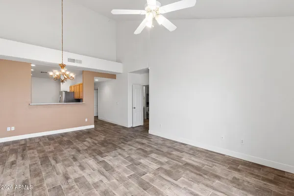 an empty room with a window and ceiling fan