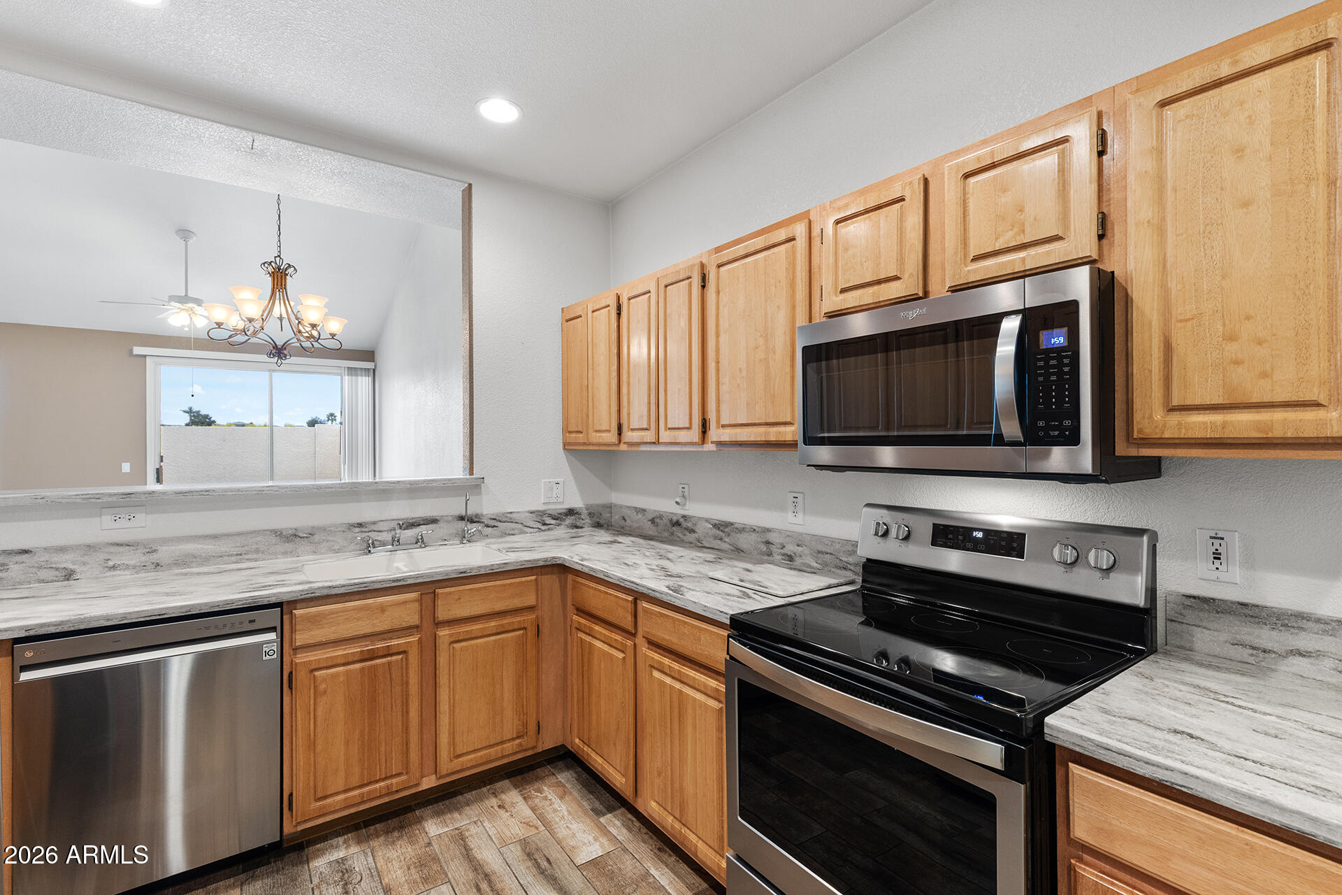 7101 West Beardsley Road, Unit 1303 Glendale, AZ 85308 - Photo 7 of 53 a kitchen with stainless steel appliances granite countertop a stove microwave and sink