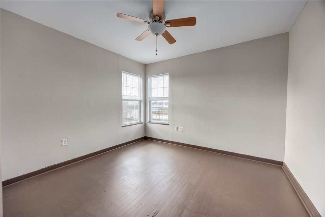2437 Nemec Street Corpus Christi, TX 78415 - Photo 11 of 38 an empty room with wooden floor chandelier fan and windows