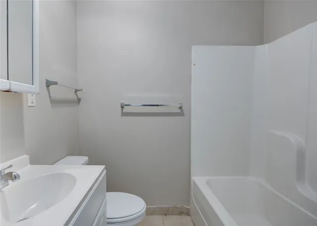a white bath tub sitting next to a white toilet and sink