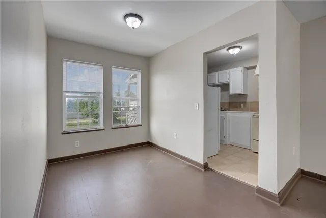 an empty room with windows and entrance