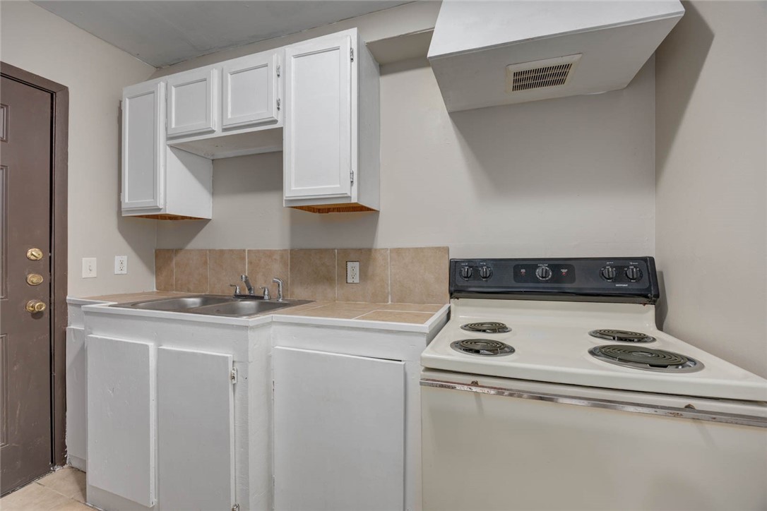 2437 Nemec Street Corpus Christi, TX 78415 - Photo 23 of 38 a kitchen with granite countertop a sink a stove and cabinets