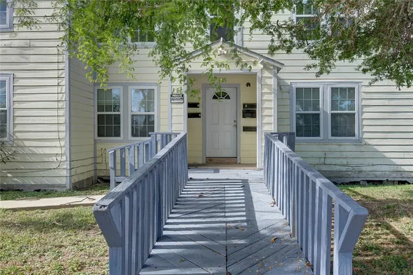 a view of a house with wooden deck front of house
