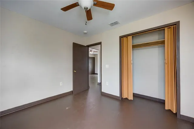 an empty room with a ceiling fan and a window