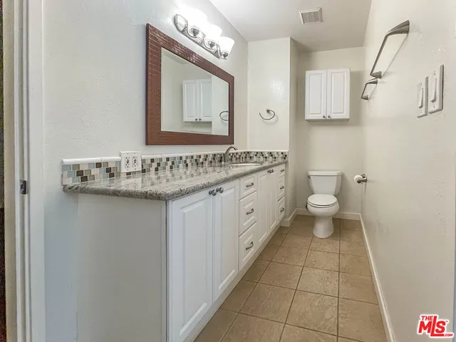 a bathroom with a sink vanity and a toilet