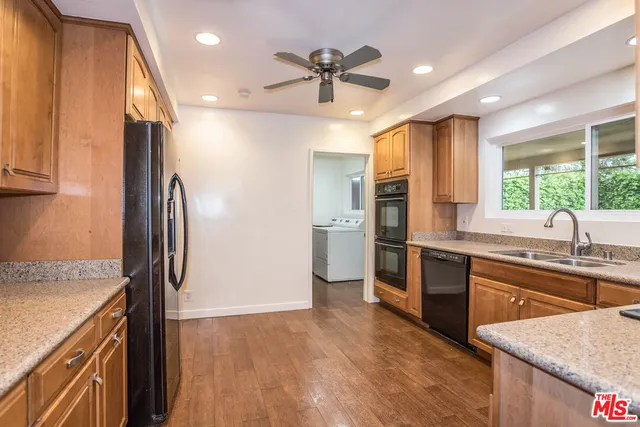a kitchen with stainless steel appliances granite countertop a refrigerator a sink and dishwasher