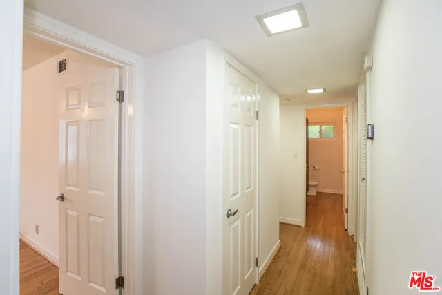 a view of a hallway with wooden floor