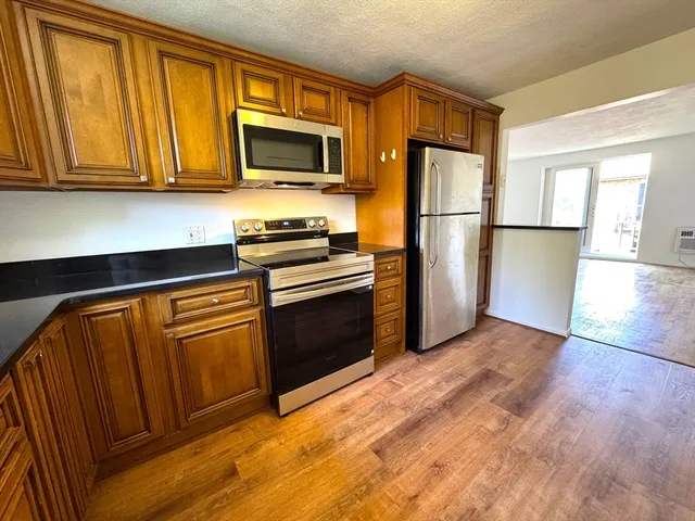 a kitchen with stainless steel appliances granite countertop a refrigerator microwave and sink