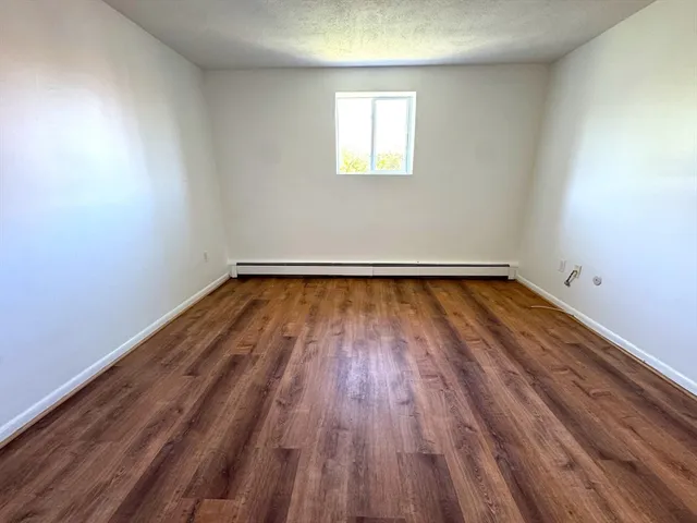 a view of a room with wooden floor and white walls