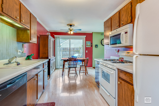 76 Fernwood Road Montgomery, IL 60538 - Photo 4 of 13 a kitchen with stainless steel appliances granite countertop a stove a sink dishwasher and cabinets with wooden floor