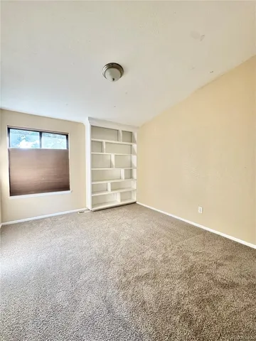 an empty room with fire place and windows