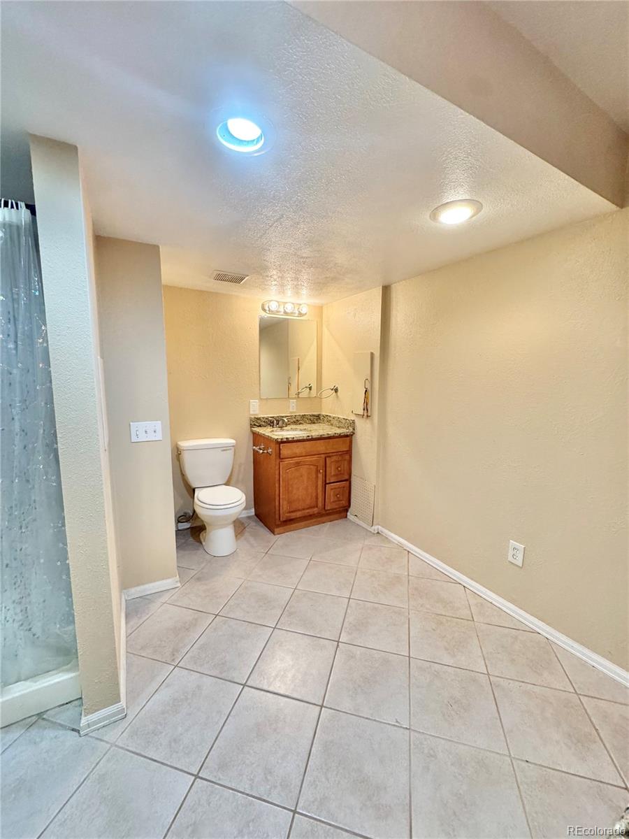 17938 East Amherst Avenue Aurora, CO 80013 - Photo 15 of 16 a bathroom with a sink a toilet and a mirror