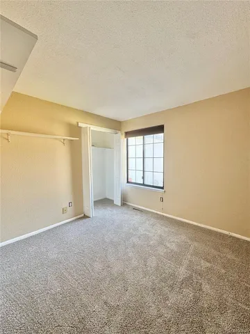 an empty room with windows & cabinet