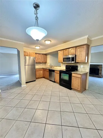 a kitchen with stainless steel appliances granite countertop a stove a sink dishwasher and a refrigerator