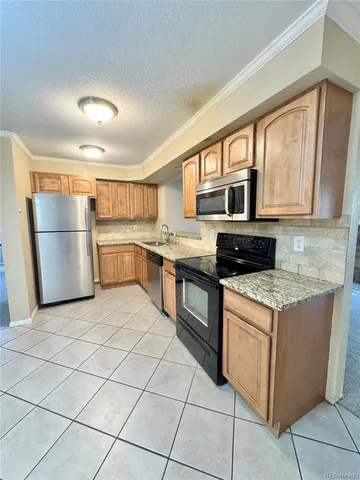 a kitchen with stainless steel appliances granite countertop a stove and a refrigerator