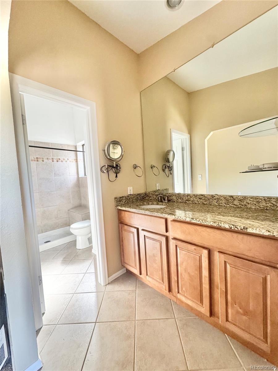17938 East Amherst Avenue Aurora, CO 80013 - Photo 10 of 16 a bathroom with a granite countertop sink and a mirror