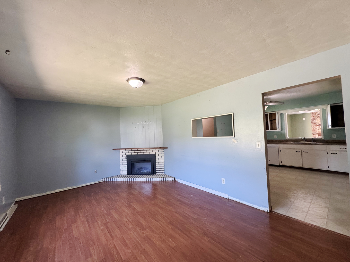 310 North 3rd Avenue Chenoa, IL 61726 - Photo 6 of 23 a view of empty room with wooden floor and fireplace