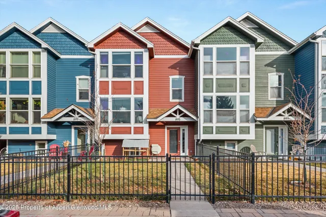 a kitchen with white cabinets stainless steel appliances and a dining table