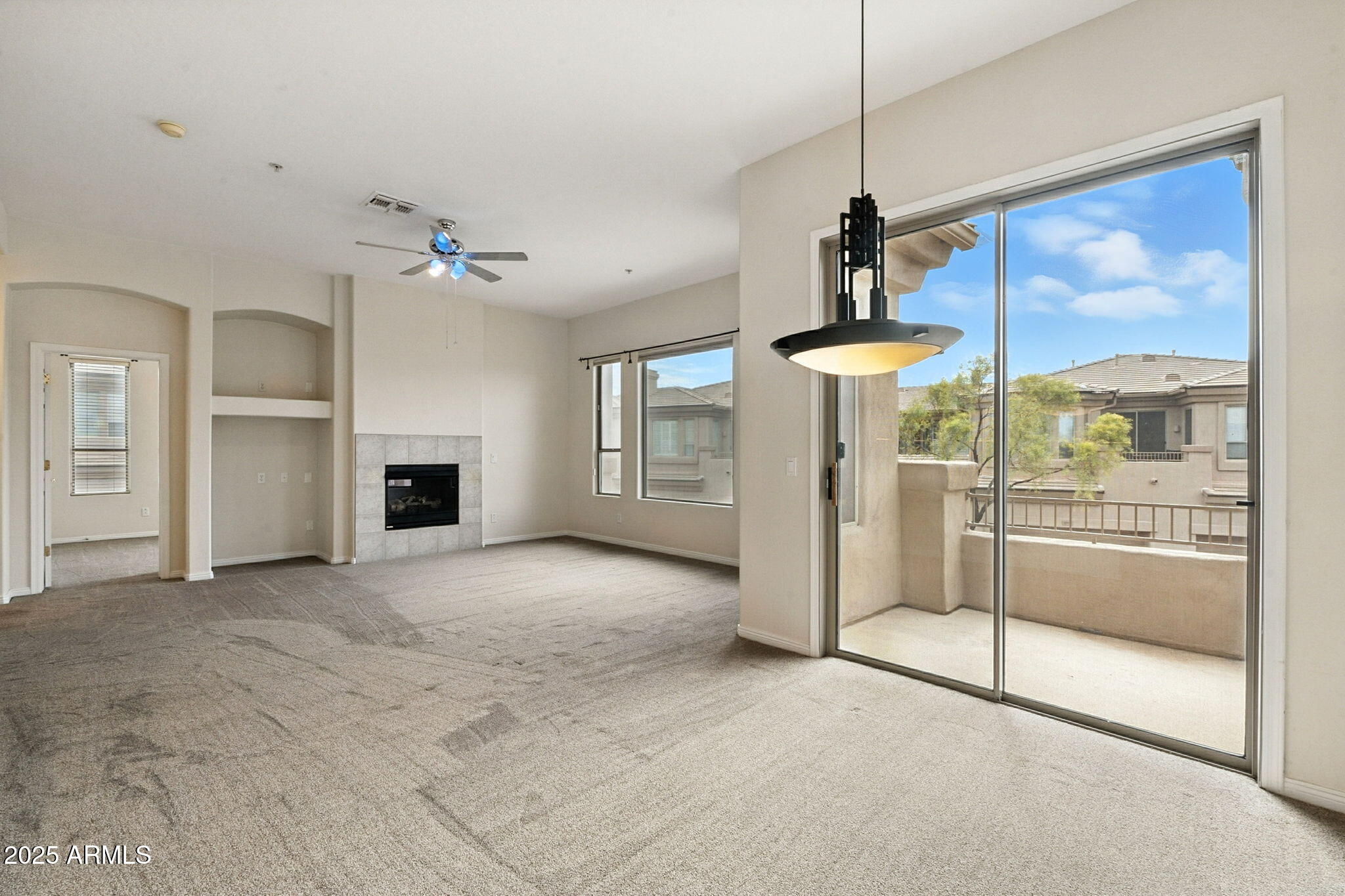 16420 North Thompson Peak Parkway, Unit 2031 Scottsdale, AZ 85260 - Photo 10 of 30 a view of a livingroom with a fireplace a ceiling fan and front door