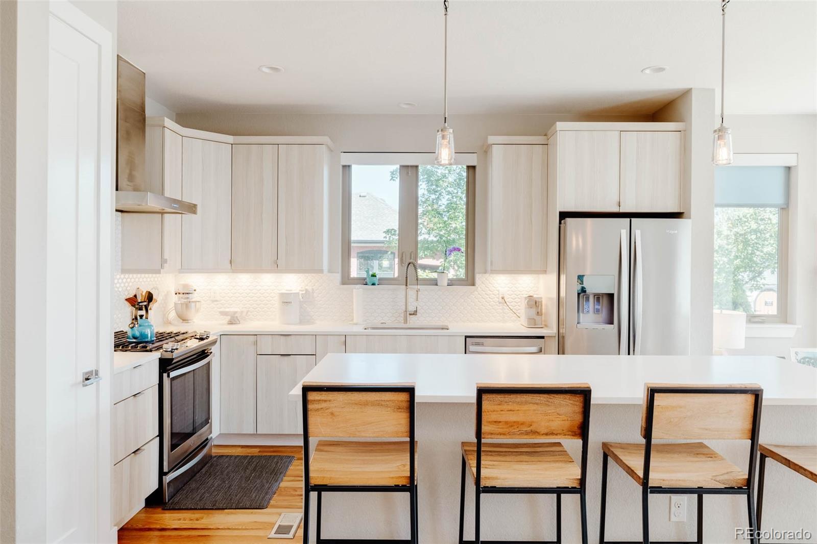 3738 Raleigh Street Denver, CO 80212 - Photo 12 of 34 a kitchen with stainless steel appliances granite countertop a stove a sink and a refrigerator with wooden floor