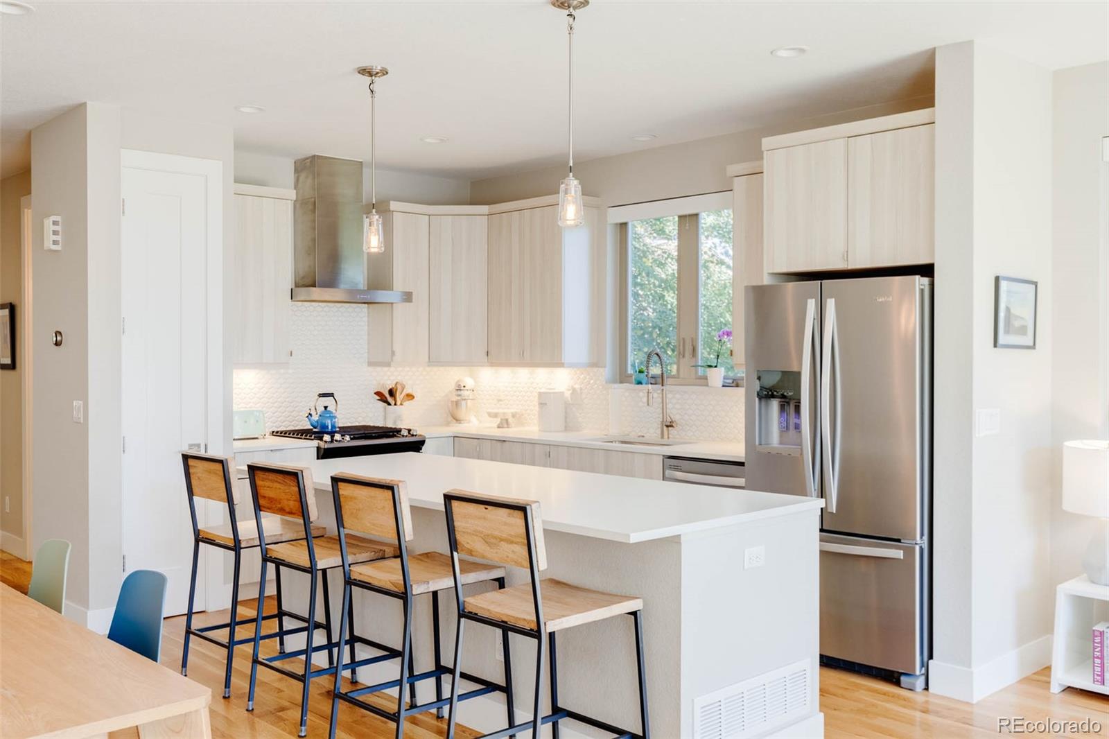 3738 Raleigh Street Denver, CO 80212 - Photo 14 of 34 a kitchen with stainless steel appliances a dining table chairs refrigerator and microwave