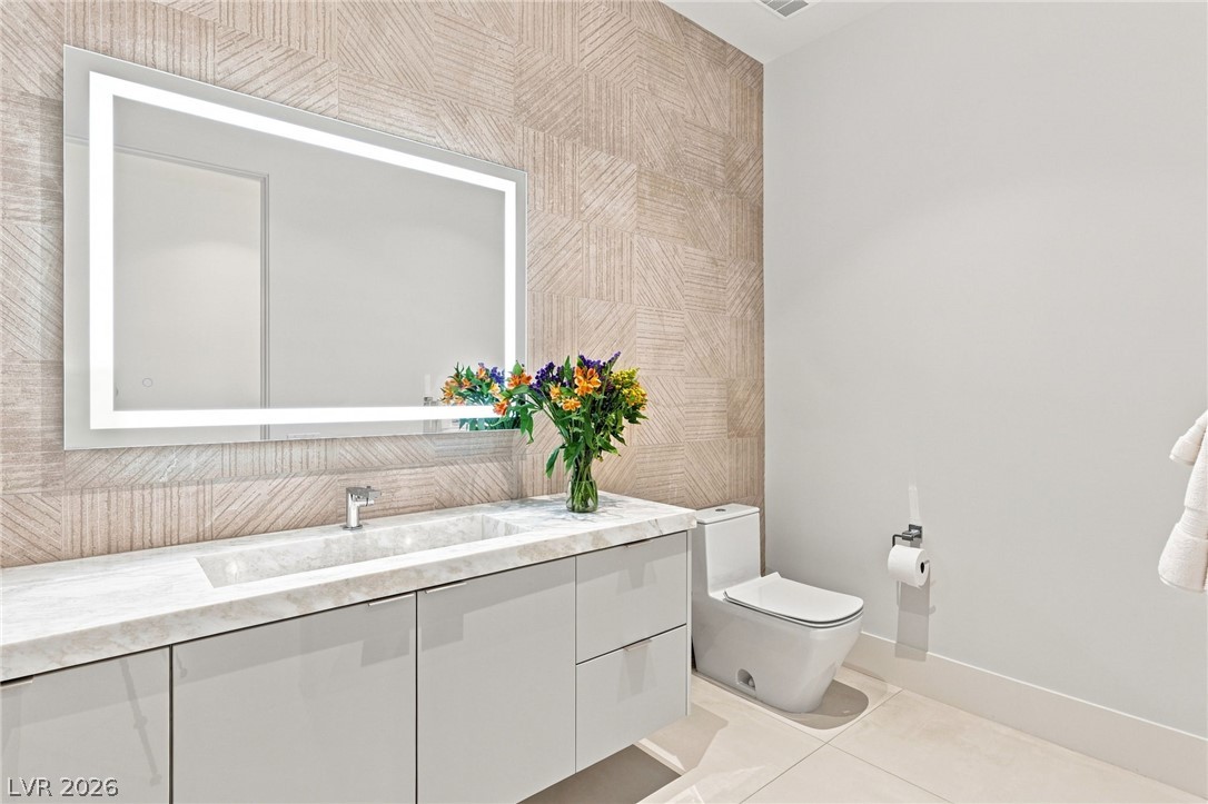 677 Overlook Rim Drive Henderson, NV 89012 - Photo 30 of 97 A floating vanity and textured accent tiling define this sleek contemporary washroom.