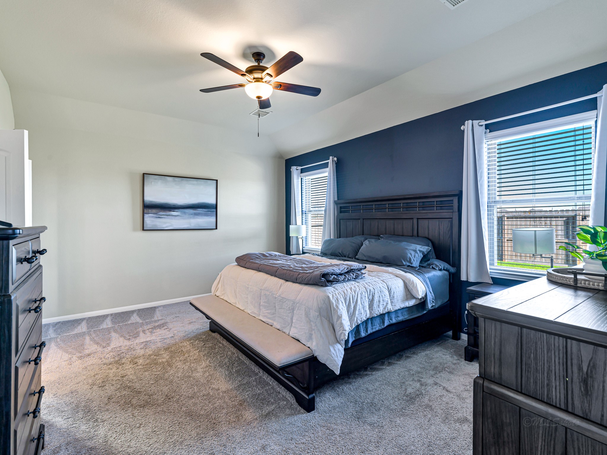 5622 Maxon Court Rosenberg, TX 77471 - Photo 14 of 23 Escape to your expansive primary suite, a true private retreat featuring high ceilings, a stylish accent wall and plenty of space for a king sized furniture ensemble! Windows to the back yard let the sun shine through!