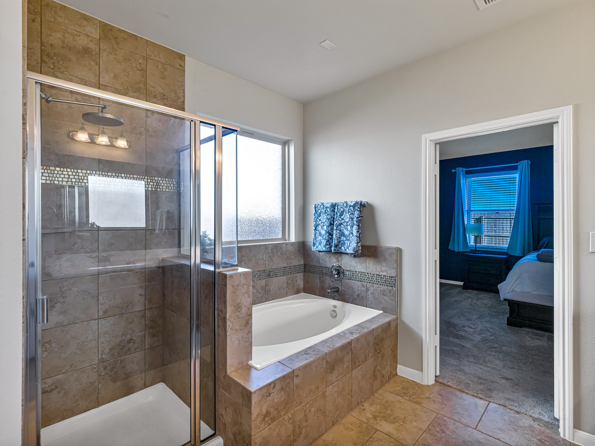 5622 Maxon Court Rosenberg, TX 77471 - Photo 15 of 23 Indulge in your en suite primary bath, complete with a deep soaking tub, custom tile work and a a separate glass-enclosed walk in shower.