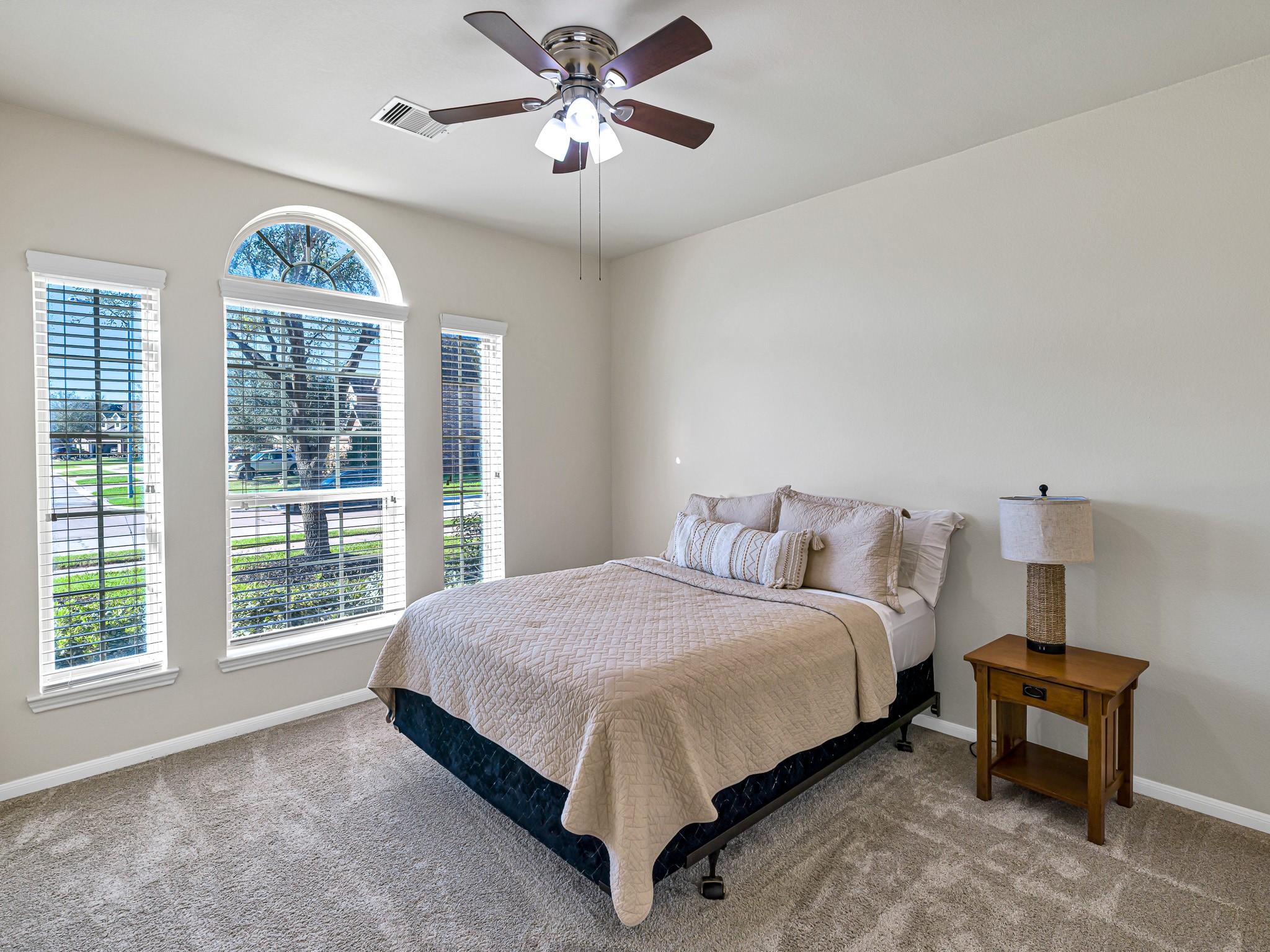 5622 Maxon Court Rosenberg, TX 77471 - Photo 17 of 23 Beautiful arched windows flood this spacious secondary bedroom with natural light, highlighting the high ceilings and natural color palette.