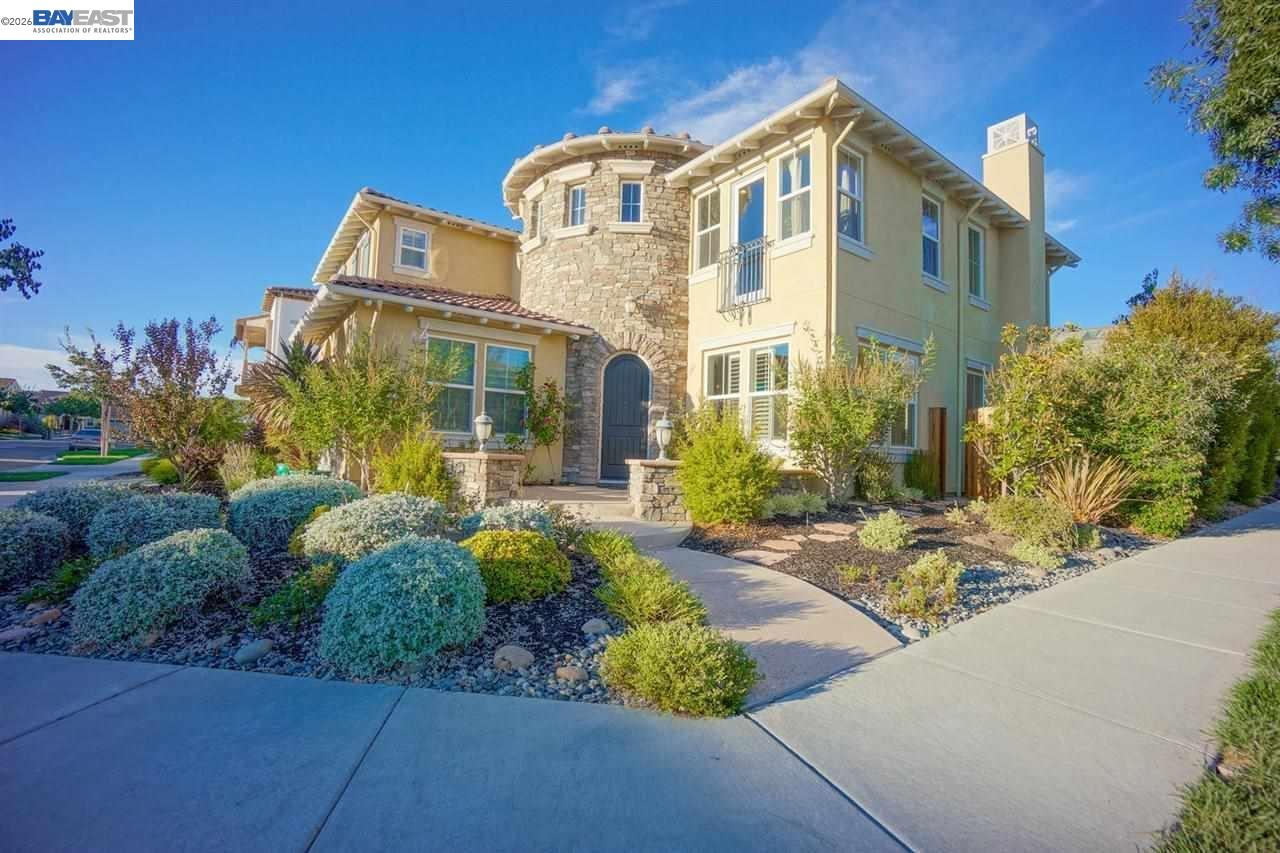 a front view of a multi story residential apartment building with yard and bench