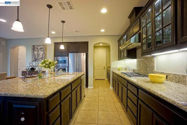 a bathroom with a granite countertop sink and a large mirror
