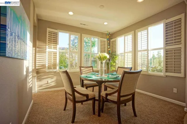 a dining room with furniture and large windows