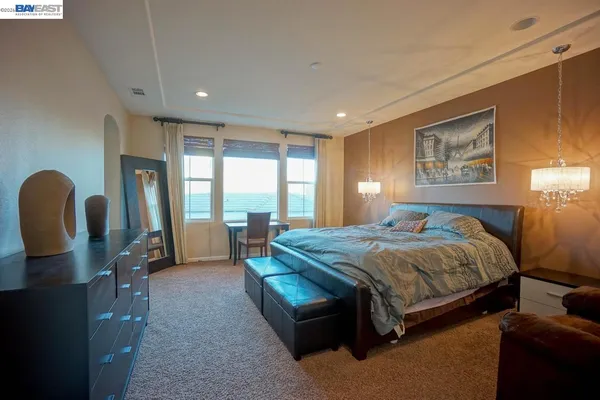 a bedroom with a bed and large windows