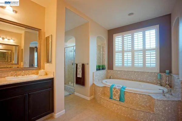 a bathroom with a tub a sink and a window