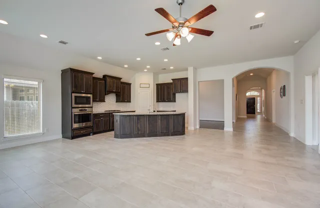 a view of kitchen with cabinets and refrigerator