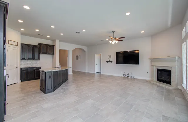 a living room with stainless steel appliances furniture a fireplace and a television