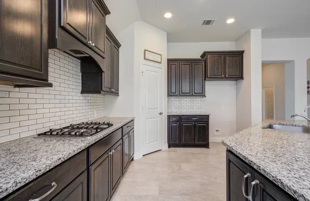 a kitchen with stainless steel appliances granite countertop a stove and a sink