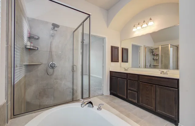 a bathroom with a double vanity sink mirror and shower