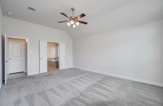 a view of an empty room with chandelier fan