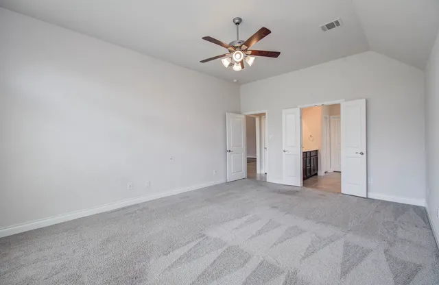 a view of an empty room with a chandelier fan