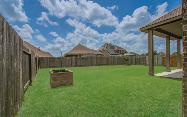 a view of a backyard with table and chairs and wooden fence