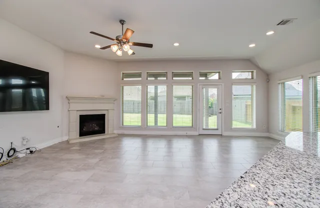 a view of an empty room with a fireplace and a window